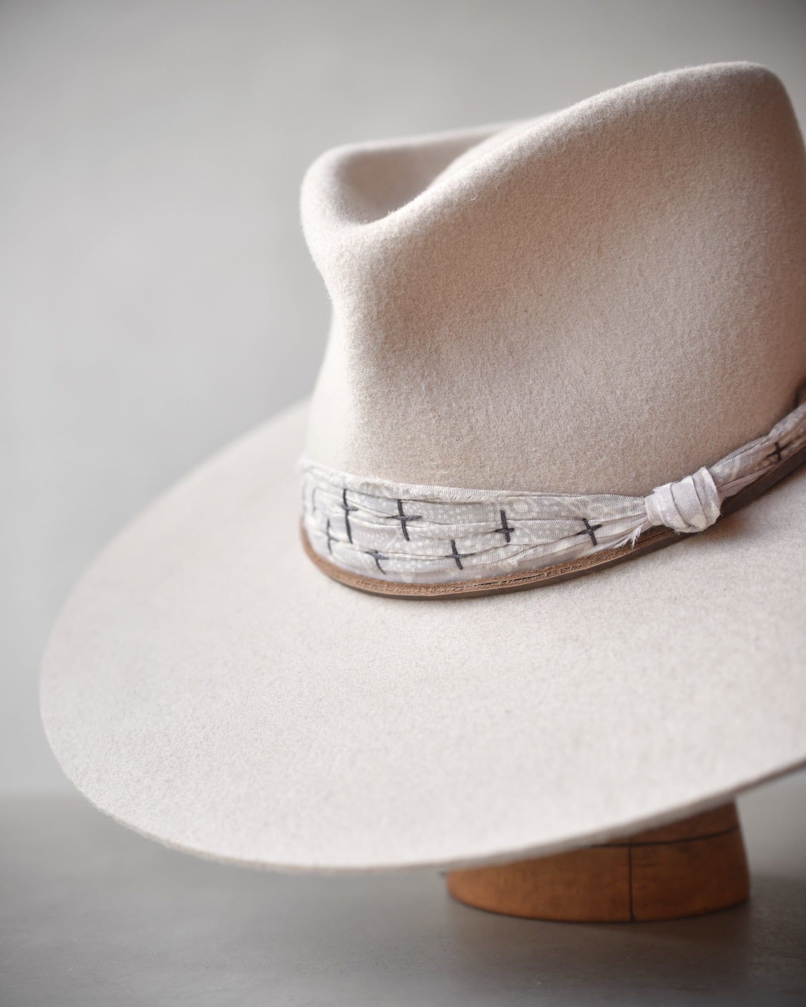 Ninakuru wool hat with cotton wrap band and leather lace.