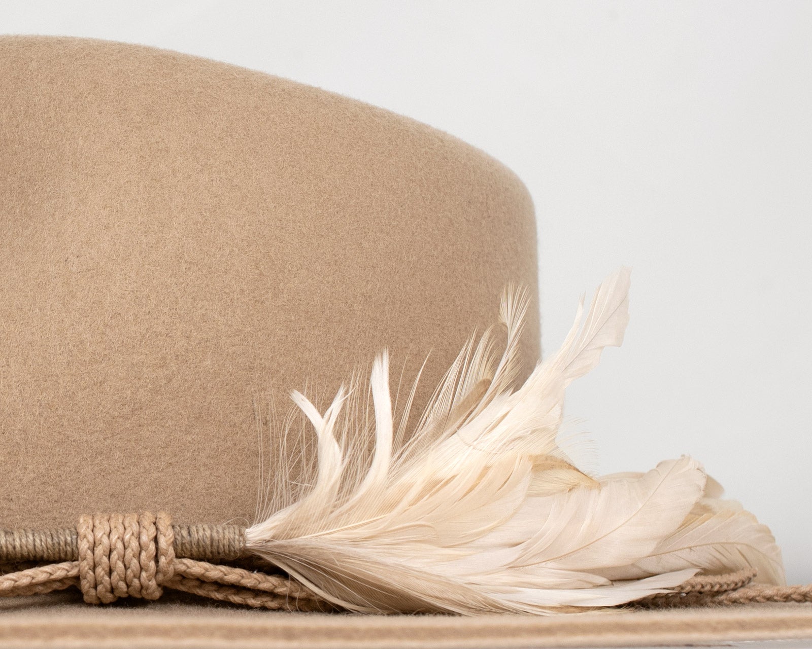 Ninakuru wool hat with braided leather and game feather.