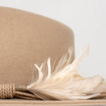 Ninakuru wool hat with braided leather and game feather.