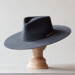 Ninakuru long brim wool hat with leather band and bronze eyelet.