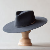 Ninakuru long brim wool hat with leather band and bronze eyelet.