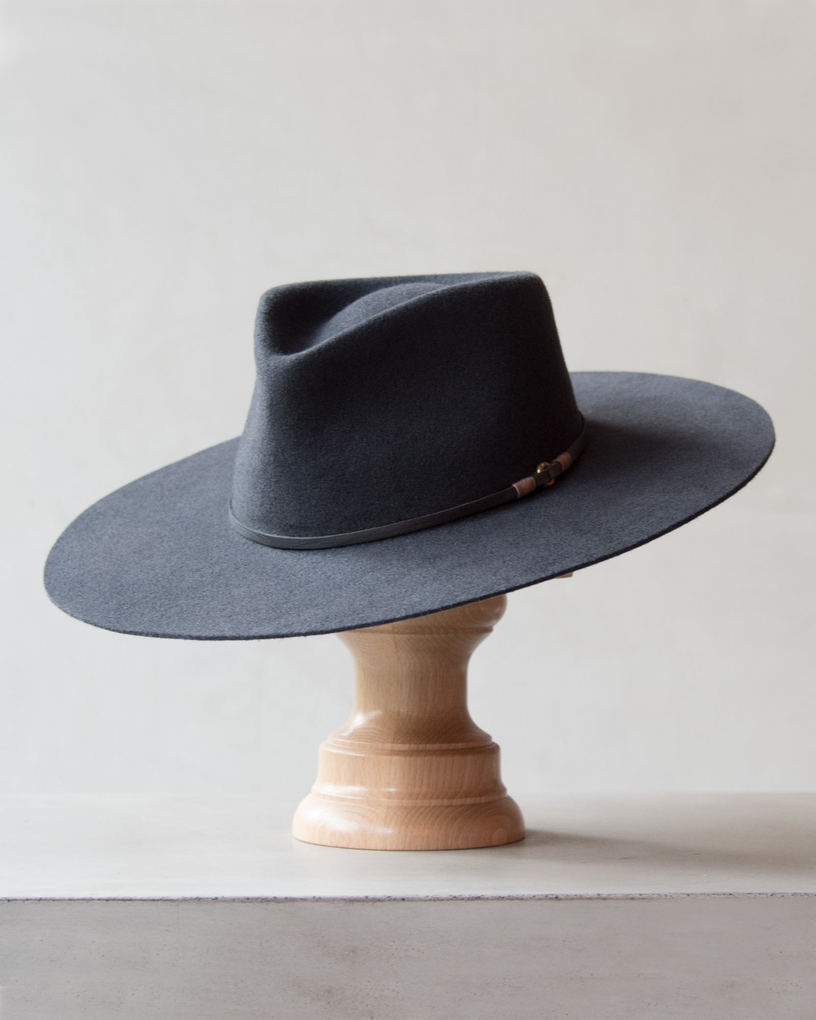 Ninakuru long brim wool hat with leather band and bronze eyelet.