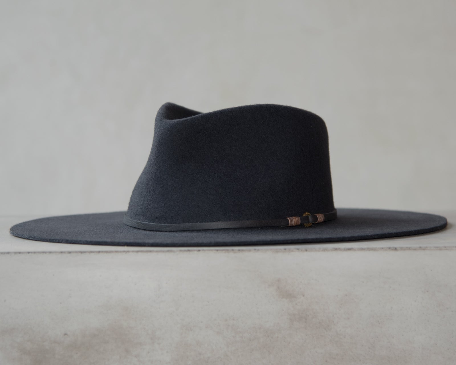 Ninakuru long brim wool hat with leather band and bronze eyelet.