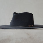 Ninakuru long brim wool hat with leather band and bronze eyelet.