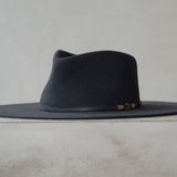 Ninakuru long brim wool hat with leather band and bronze eyelet.
