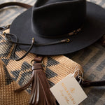 Ninakuru long brim wool hat with leather band and bronze eyelet.