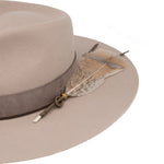 Ninakuru wool hat with leather band, feather and bronze.