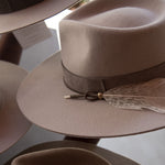 Ninakuru wool hat with leather band, feather and bronze.