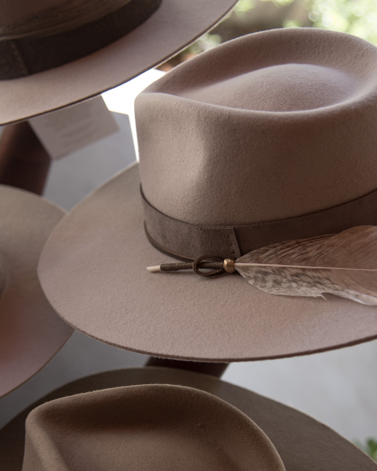 Ninakuru wool hat with leather band, feather and bronze.