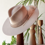 Ninakuru wool hat with leather band, feather and bronze.