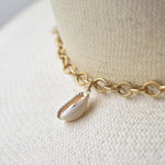 Ninakuru Panama straw hat with gold tone chain and seashells.