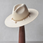Ninakuru Panama straw hat with gold tone chain and seashells.