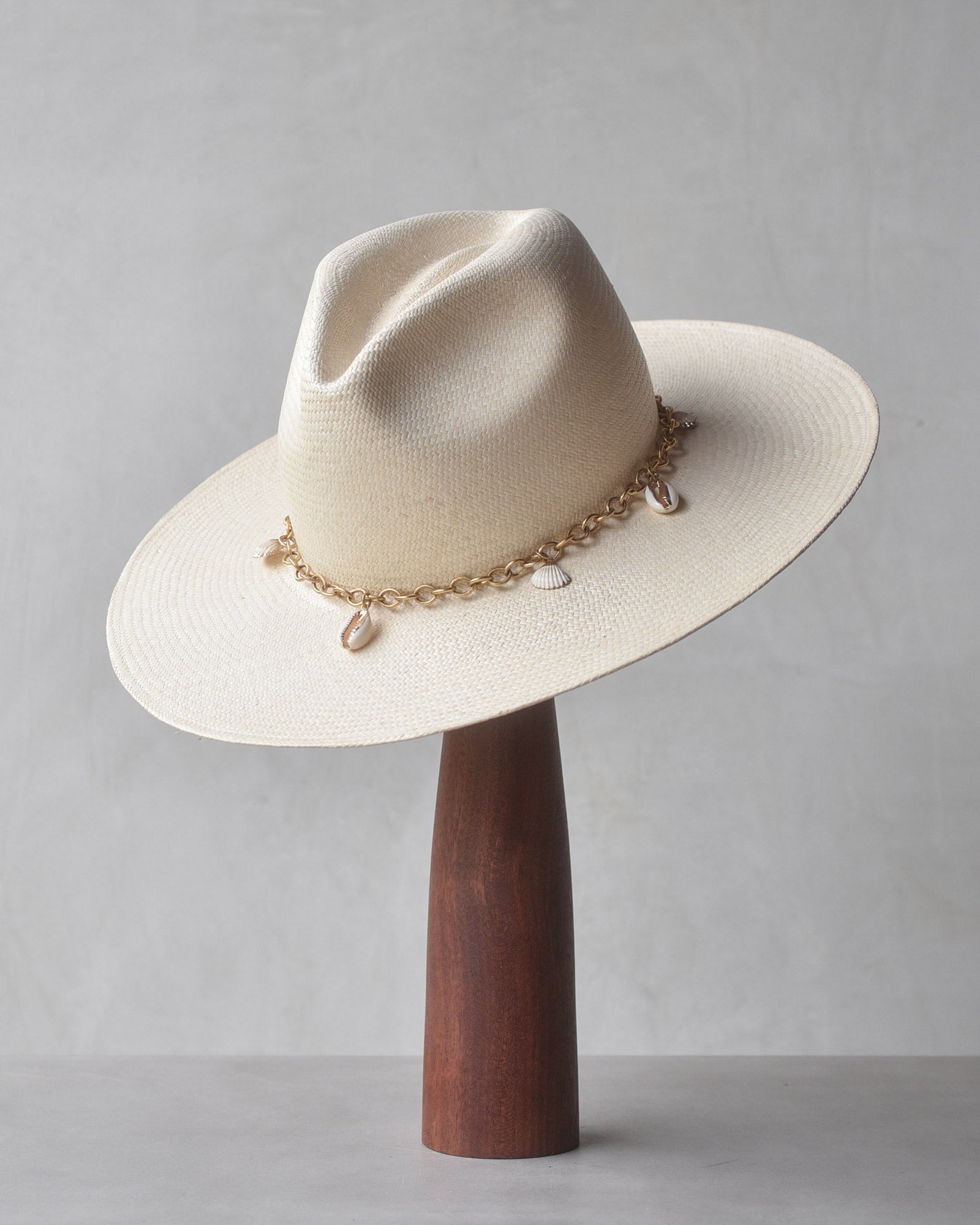 Ninakuru Panama straw hat with gold tone chain and seashells.